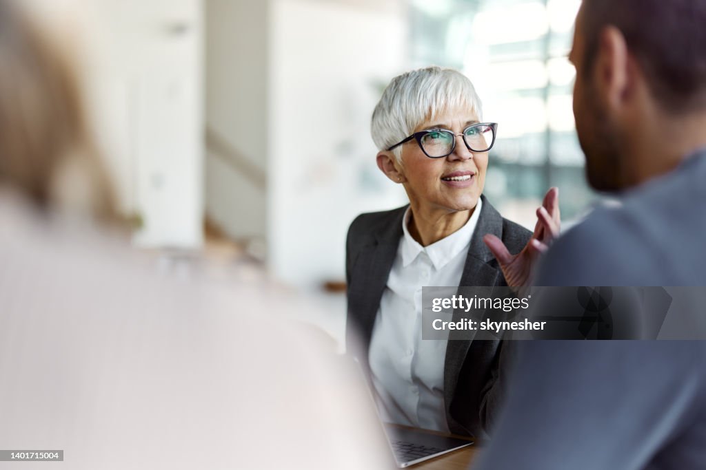 Agente de seguros hablando con sus clientes en una reunión en la oficina.