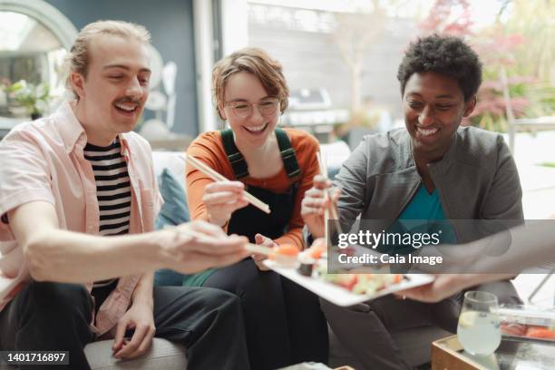 happy friends sharing sushi lunch - eating sushi stock-fotos und bilder