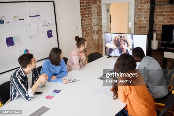 businesswoman having online briefing with team in a hybrid office - distant meeting stock pictures, royalty-free photos & images