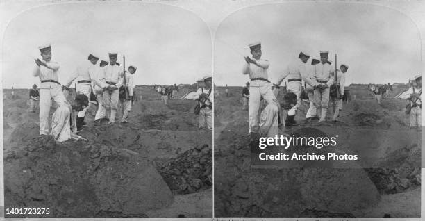Stereoscopic image showing an Chinese criminal kneeling over his own freshly-dug grave as Japanese executioner swings his a blade to behead the...