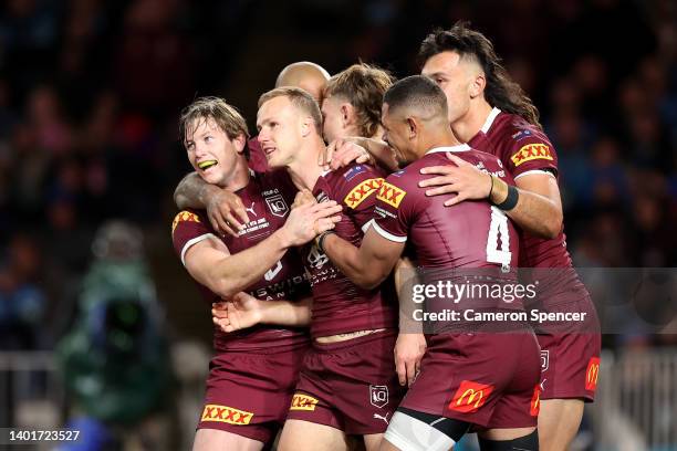 Daly Cherry-Evans of the Maroons celebrates with teammates after scoring a try during game one of the 2022 State of Origin series between the New...