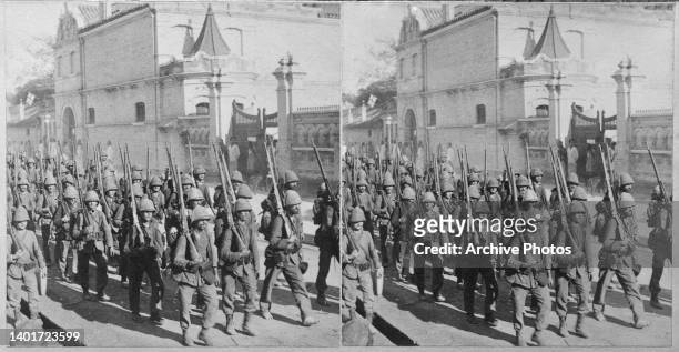 Stereoscopic image showing French marines marching with their rifles during the Boxer Rebellion, entering Beijing, China, circa 1900. The French are...