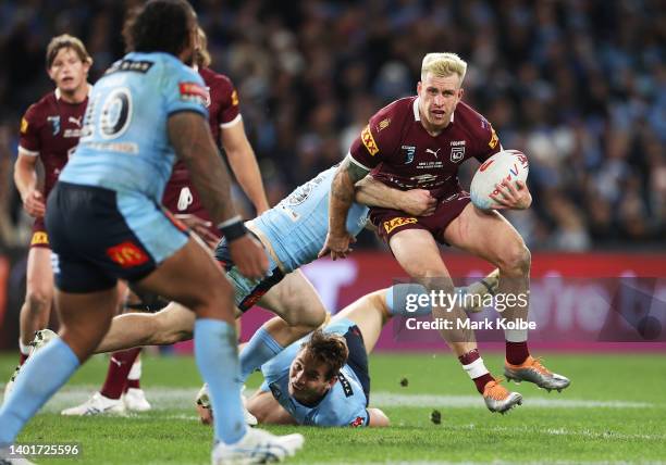 Cameron Munster of the Maroons is tackled during game one of the 2022 State of Origin series between the New South Wales Blues and the Queensland...