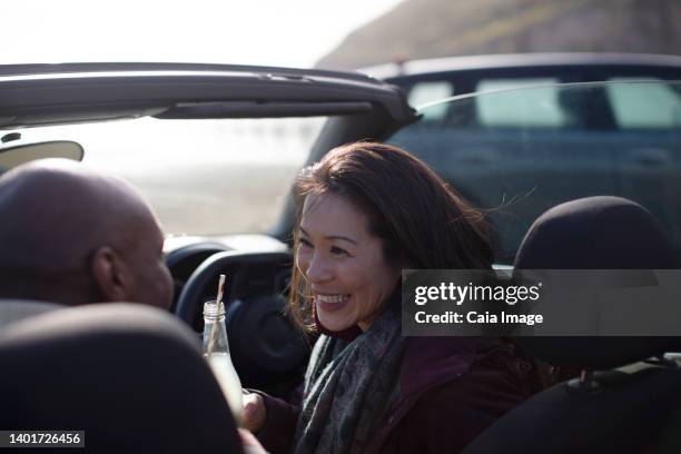 happy couple drinking soda in convertible - drinking soda in car stock pictures, royalty-free photos & images