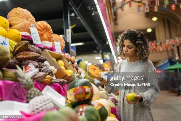 tourist buys fruit at the são paulo municipal market - feira árabe ao ar livre imagens e fotografias de stock