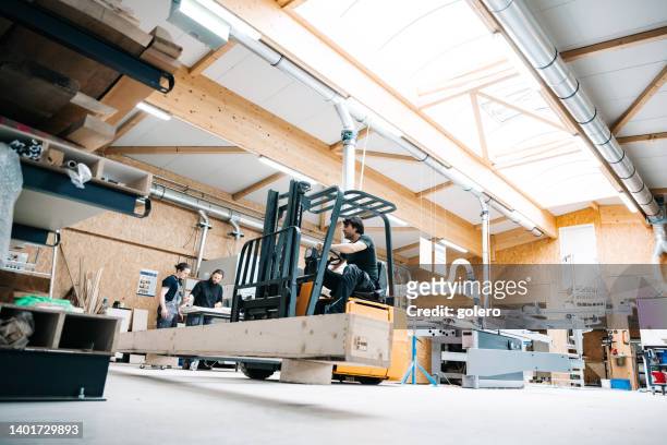 trabajador con carretilla elevadora en la sala de fabricación de carpintería frente al estante de almacenamiento - típico de clase mediana fotografías e imágenes de stock