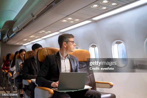 los pasajeros están sentados en el avión comercial. - cabina interior del vehículo fotografías e imágenes de stock