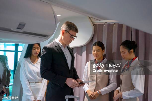 passengers are sitting in the commercial plane. - airhostess stock pictures, royalty-free photos & images