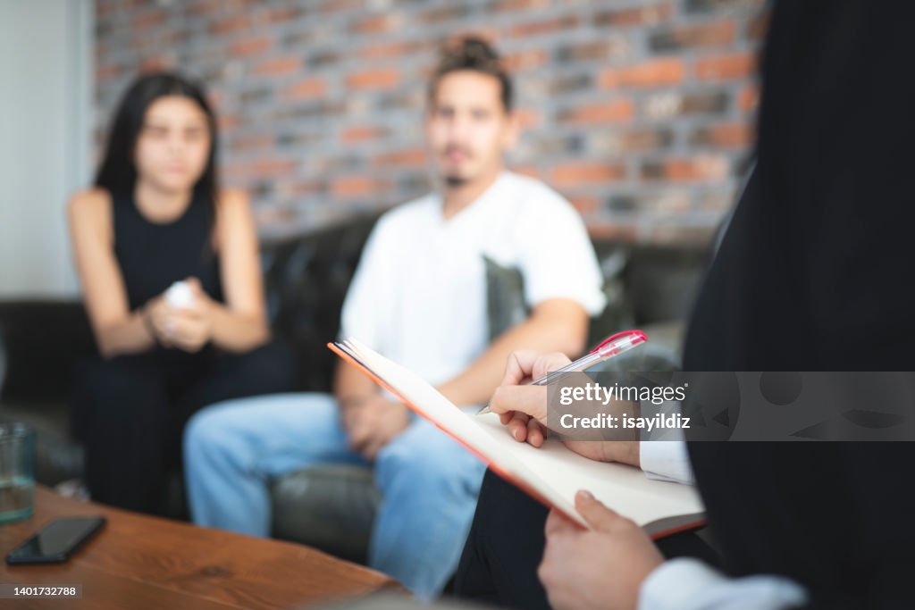 Psychologist is listening to problems of young couple