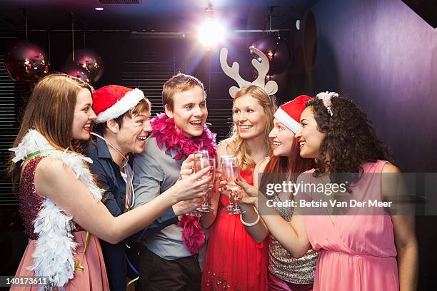 friends toasting champagne at christmas  party - christmas party stockfoto's en -beelden