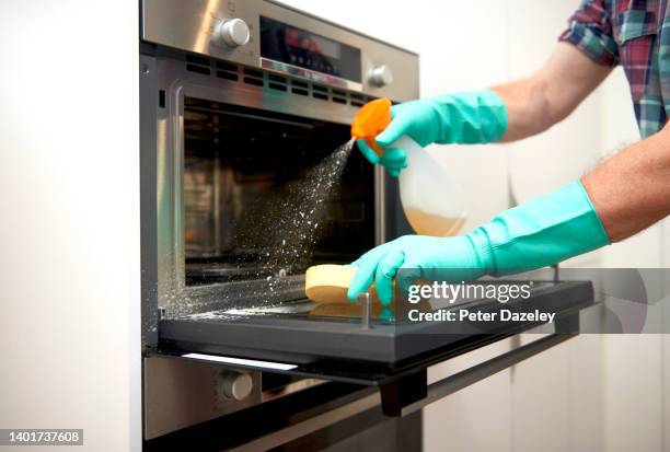 senior man cleaning oven - clean oven stock pictures, royalty-free photos & images