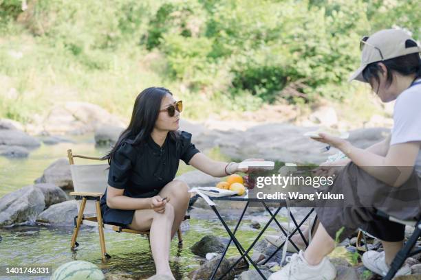 three women having a picnic by the river - asia village river stock pictures, royalty-free photos & images