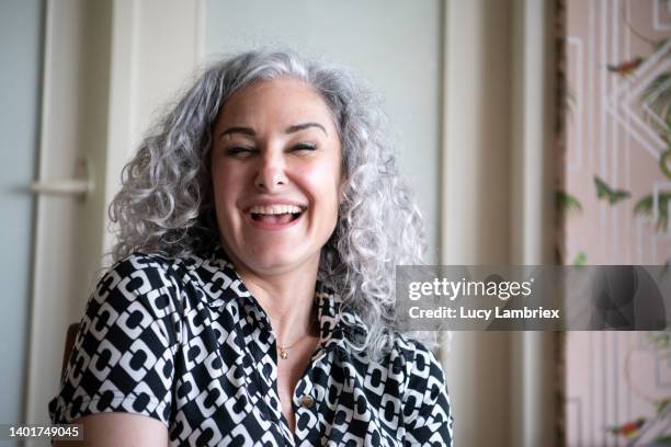 portrait of a beautiful gray-haired woman laughing - toma mediana fotografías e imágenes de stock