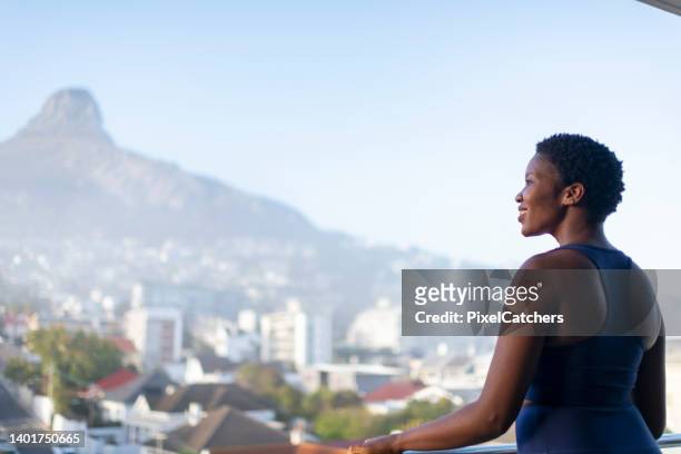 woman looks out at morning city view with mountain peak - south africa landscape stock pictures, royalty-free photos & images