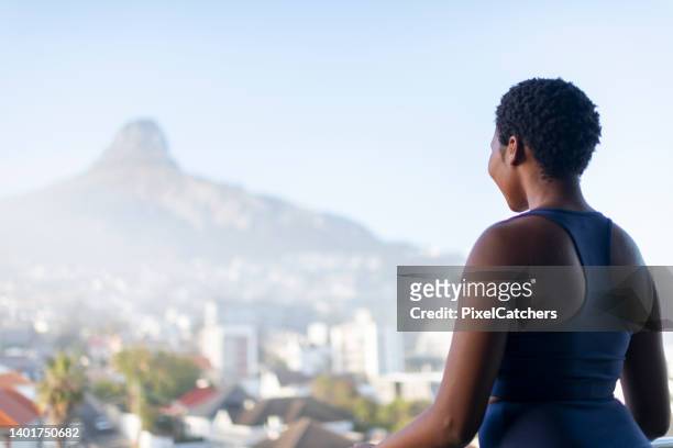 back view woman looks over city to mountain peak - cape town cityscape stock pictures, royalty-free photos & images
