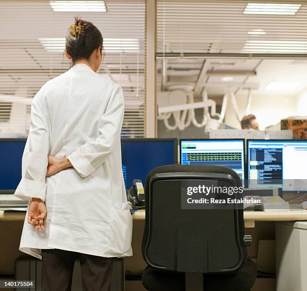 doctor watches surgery - hands behind back stock photos et images de collection