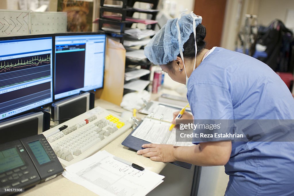 Nurse prepares surgical paperwork