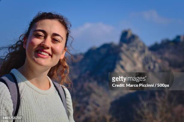 portrait of smiling young woman against mountains,regional park sassi di roccamalatina,guiglia,modena,italy - guiglia stock pictures, royalty-free photos & images