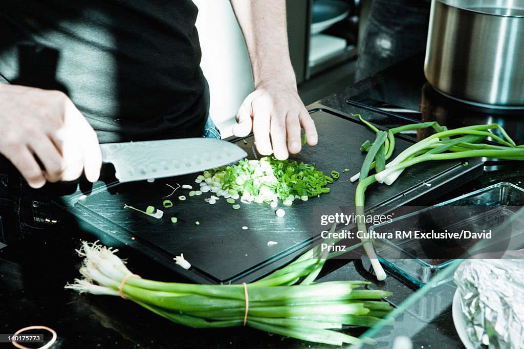 Chef chopping onions on board