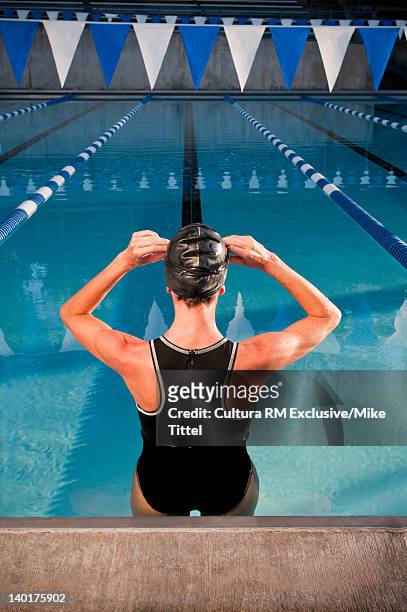 swimmer putting on goggles in pool - swimming lanes stock pictures, royalty-free photos & images