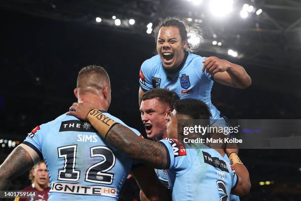 Jack Wighton of the Blues celebrates with Tariq Sims, Brian To’o and Jarome Luai after scoring a try during game one of the 2022 State of Origin...