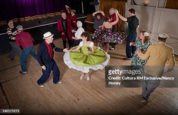 older couples dancing in auditorium - danser le rock photos et images de collection