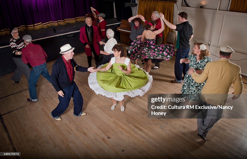 Older couples dancing in auditorium