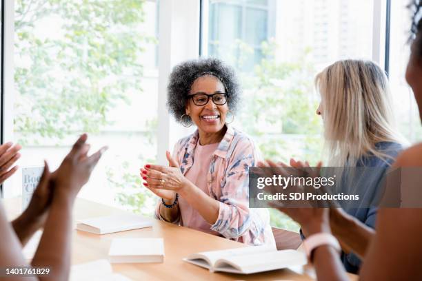 members of book club applaud and thank female leader - book club meeting stock pictures, royalty-free photos & images