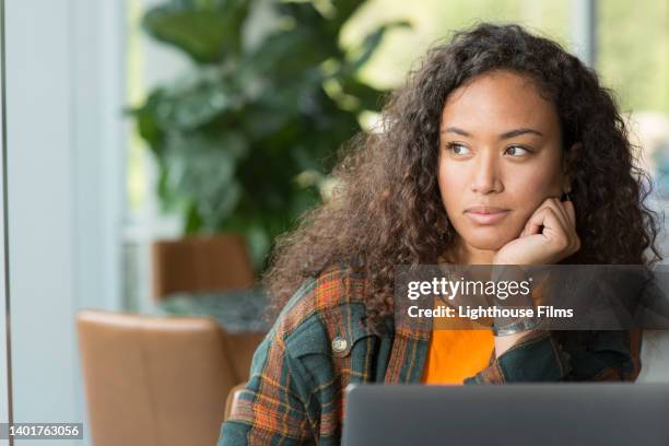 portrait of beautiful woman looking out cafe window - introspektion stock-fotos und bilder