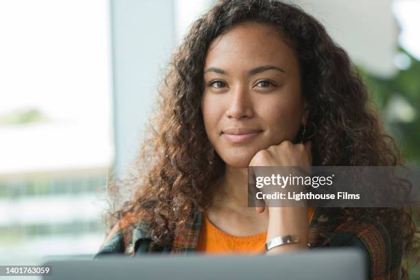 cu. portrait of beautiful woman sitting inside cafe using laptop - sorriso discreto imagens e fotografias de stock