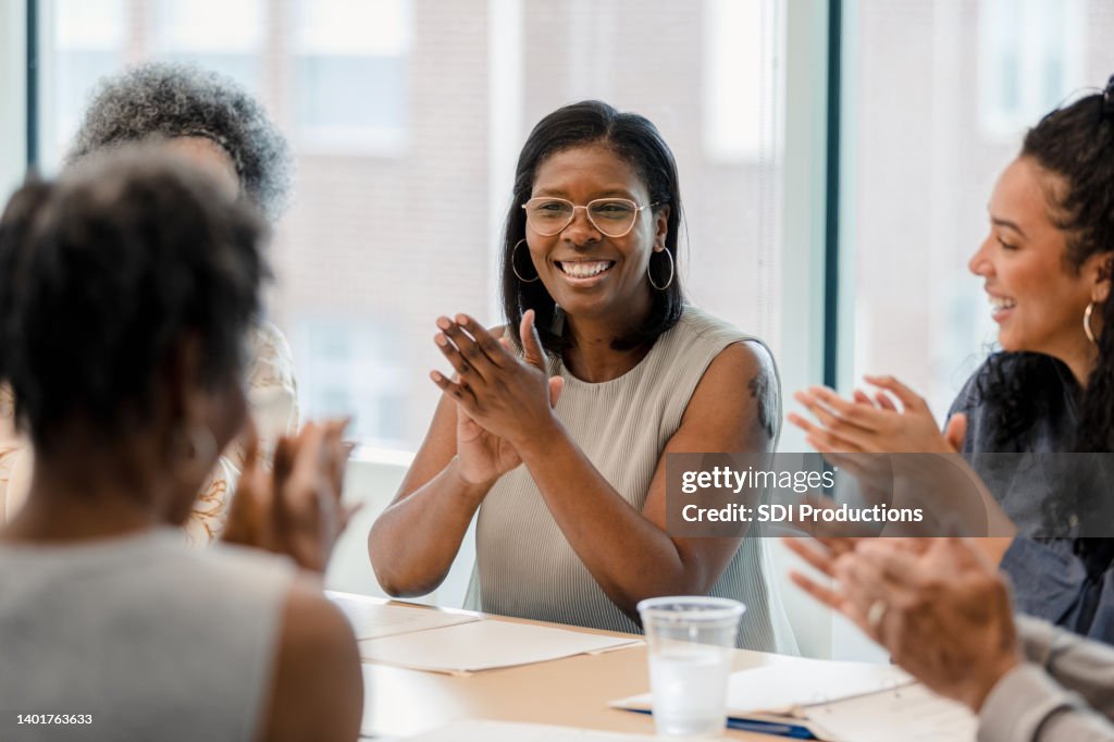 Group of employees smile and applaud after successful year