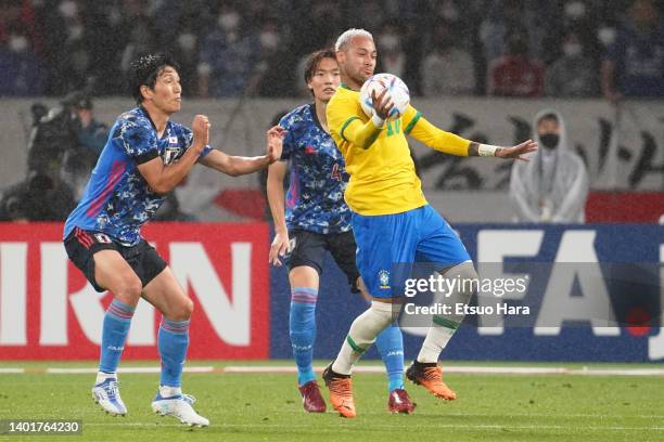 Neymar Jr. Of Brazil in action under pressure from Genki Haraguchi and Kou Itakura of Japan during the international friendly match between Japan and...