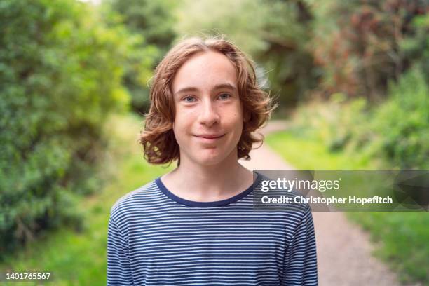 happy teenage boy in park - boy with long hair stock pictures, royalty-free photos & images