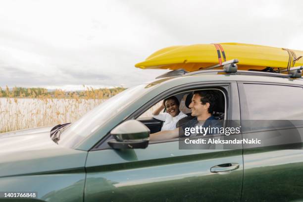 pareja sonriente de camino al lago - kayak fotografías e imágenes de stock