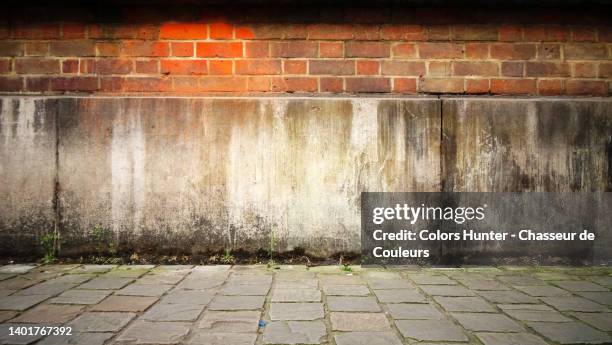 old concrete and brick wall with cobbled sidewalk and a light effect on a wall in brussels - abandon stock pictures, royalty-free photos & images