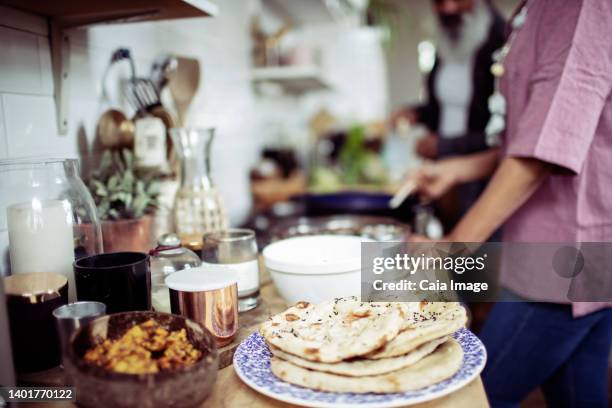 woman making flatbread at kitchen stove - roti stock pictures, royalty-free photos & images