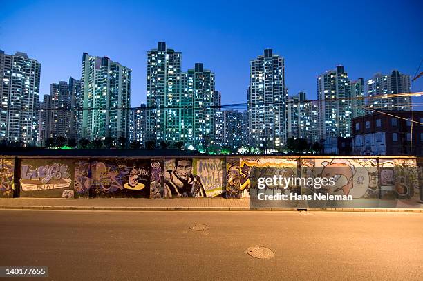 china, shanghai, district of puxi, wall with graffiti and skyline at night - graffiti wall stockfoto's en -beelden