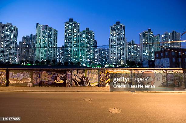 china, shanghai, district of puxi, wall with graffiti and skyline at night - graffiti wall stock pictures, royalty-free photos & images