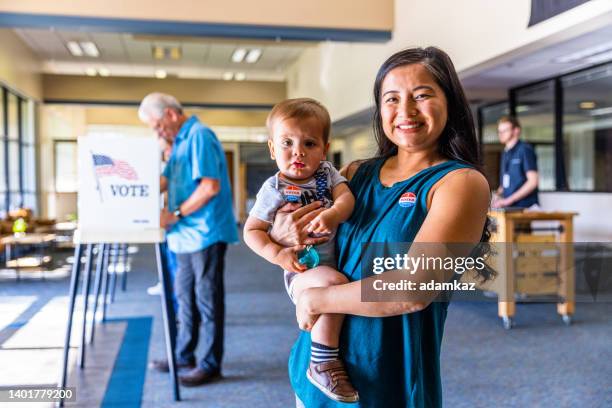 filipino woman and her baby boy after voting in an american election - american influenced 個照片及圖片檔