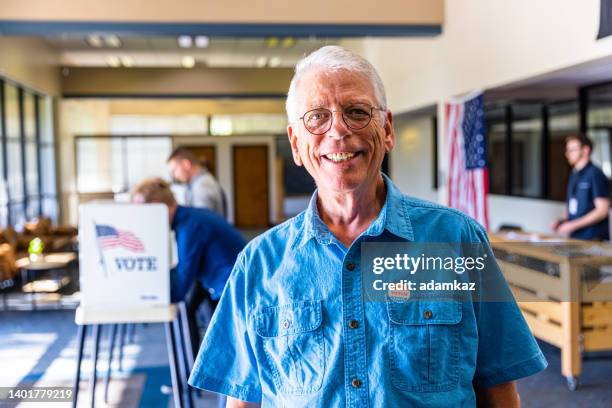 senior man smiling after voting in an american election - american influenced 個照片及圖片檔