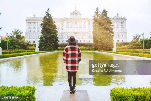 woman  in park looking towards the royal palace of madrid - madrid foto e immagini stock