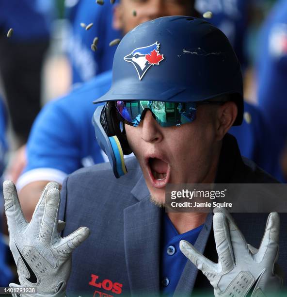 Zack Collins of the Toronto Blue Jays is congratulated by teammates in the dugout after hitting a home run during the 3rd inning of the game against...