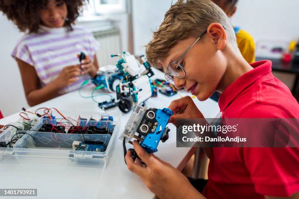 les enfants programment des jouets électriques dans une classe de robotique - atelier enfant photos et images de collection