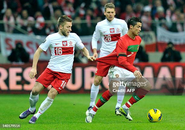 Polish midfielder Jakub Blaszczykowski garbs the jersey of Portuguese striker Cristiano Ronaldo during an international football friendly match...
