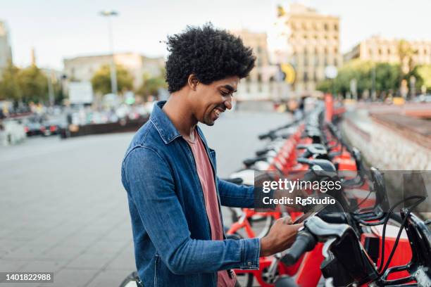 portrait of a young afro tourist renting an e-bike. - bicycle rental stock pictures, royalty-free photos & images