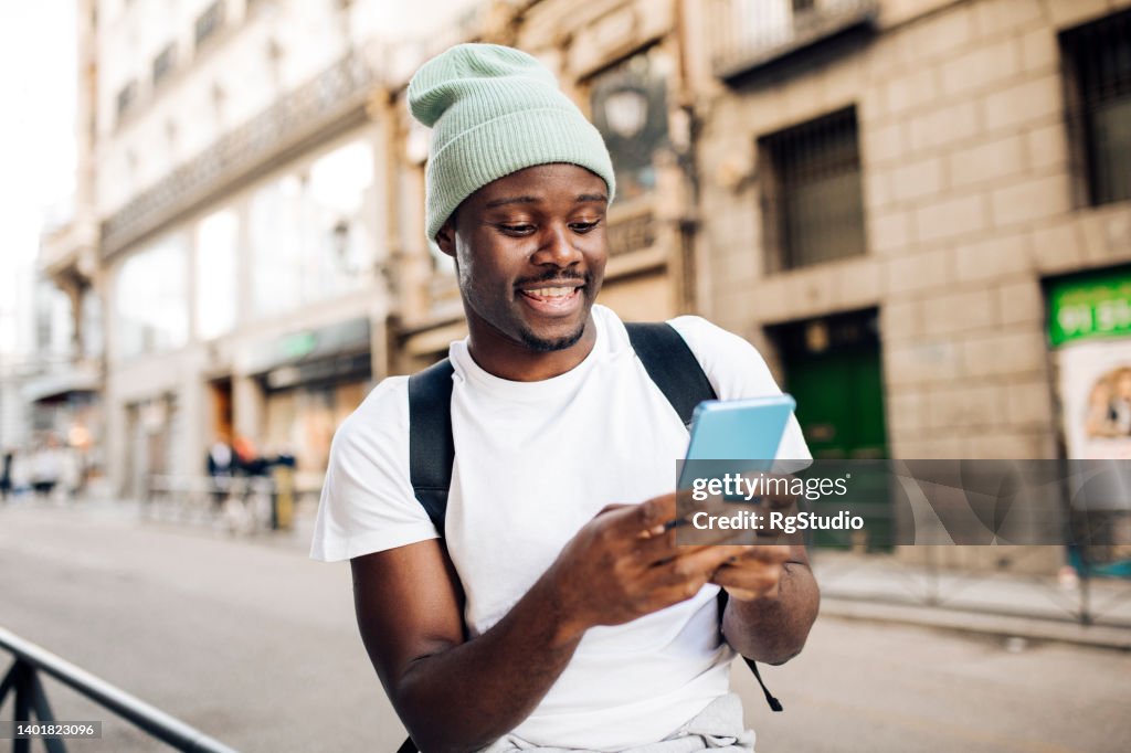 Portrait of African American tourist using smartphone on the move