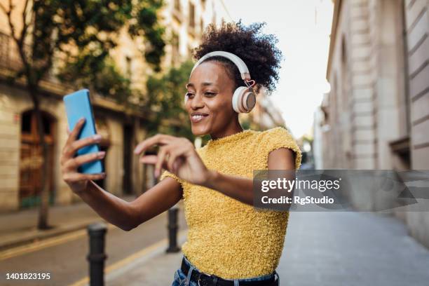 afro girl appréciant la musique dans la rue de barcelone - performer stock photos et images de collection