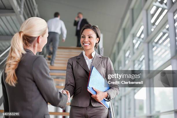 businesswoman handshaking on stairs - group of businesspeople standing low angle view stock pictures, royalty-free photos & images