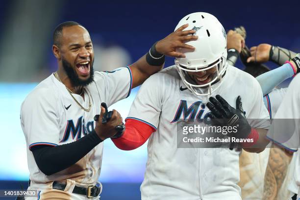 Jesus Aguilar of the Miami Marlins celebrates with Bryan De La Cruz after hitting a walk-off single during the tenth inning against the Washington...