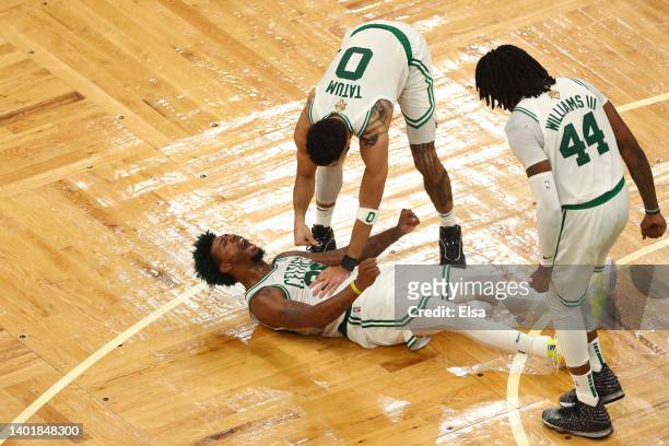 Marcus Smart of the Boston Celtics reacts to a play with teammates Jayson Tatum and Robert Williams III of the Boston Celtics in the fourth quarter...